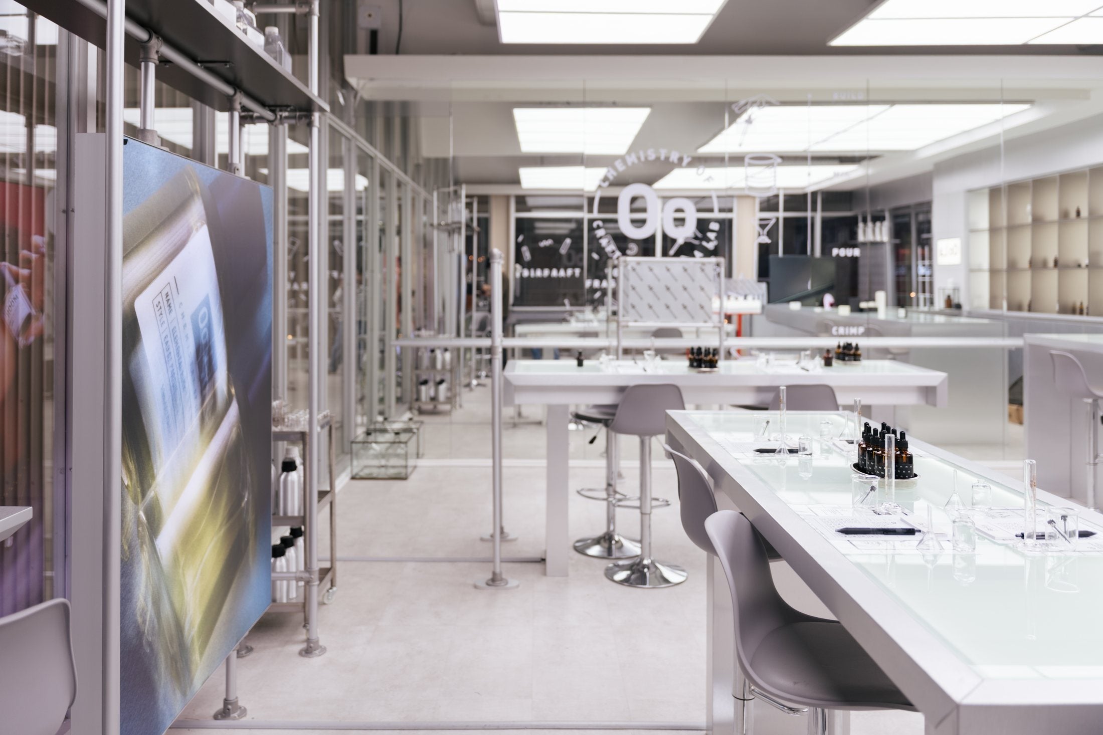 An empty, brightly lit fragrance studio seen from the entrance, with the work tables waiting.